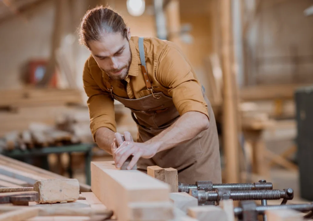 Menuisier au travail sur une pièce de bois dans un atelier